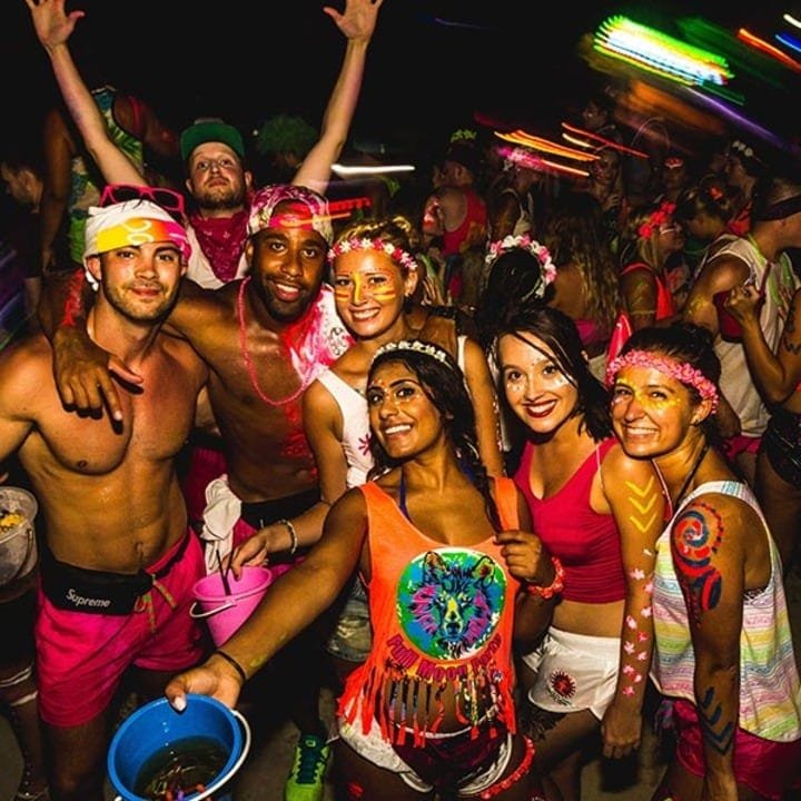 A party in classic thailand style with neon paint and cocktails out of sand buckets