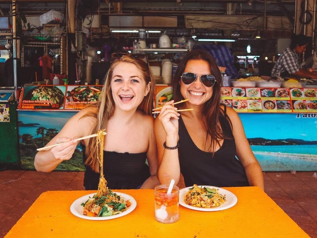 Girls eating pad thai in thailand