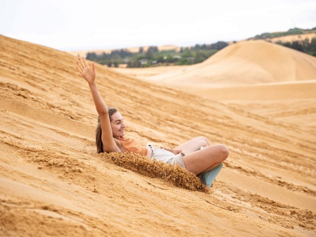 woman sand boarding in the sand dunes 