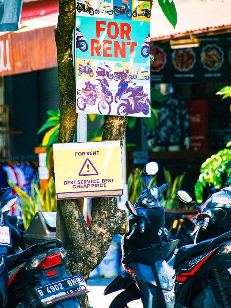 A picture of motorbikes in Bali with a sign saying "For Rent".
