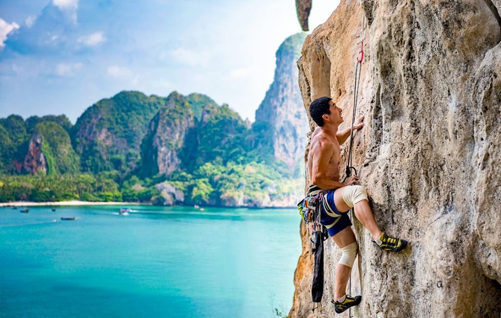 A picture of a man rock climbing at Railay Beach.