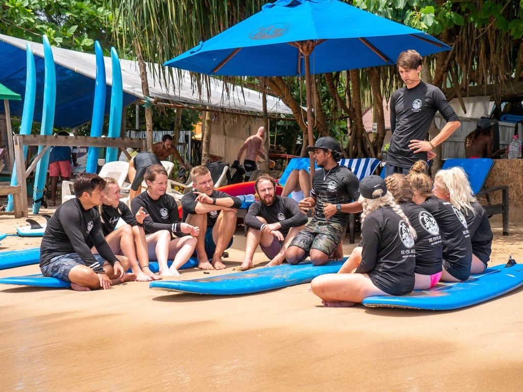 Group surf lesson on a sandy beach with surfboards laid out in preparation, capturing the essence of beachside sports and learning