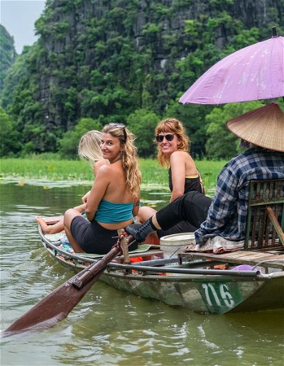 Traditional row boats through rivers, caves & rice fields